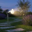 Mega stainless steel solar spotlight spiked into soil among pink hydrangeas at dusk