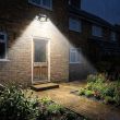 Compact Solar Security Floodlight With Three Adjustable Heads Mounted Above A Back Door Illuminating The Garden Path At Night