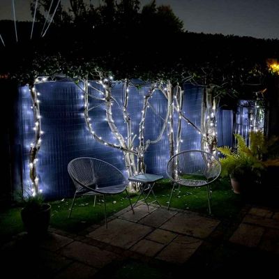 Hybrid Solar String Lights with USB Charging show me a customer's garden At night time