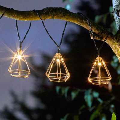 Geo Solar String Lights hanging in tree close up of copper cage