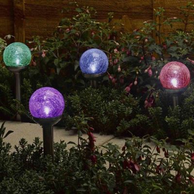 Rainbow Glass Stake Lights 4 pk at night illuminating garden border