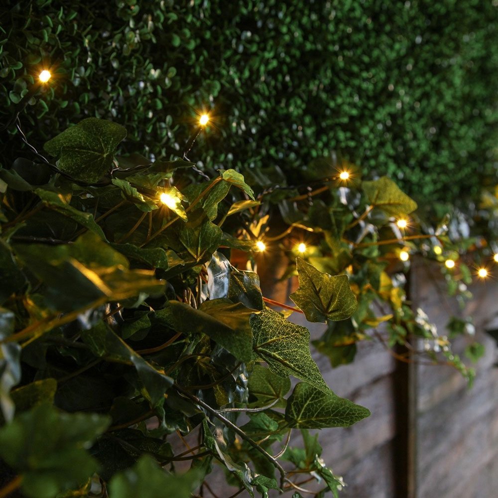 Solar Powered Firefly String Lights 100 Warm White on fence bush
