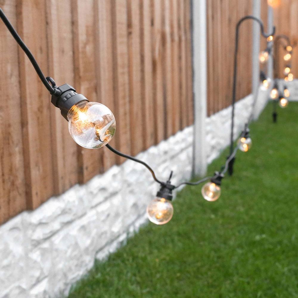 Outdoor Festoon Lights Clear Bulbs Black Cable in garden on shepherd crooks