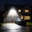 Compact Solar Security Floodlight With Three Adjustable Heads Mounted Above A Back Door Illuminating The Garden Path At Night