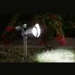 Mega stainless steel solar spotlight spiked into soil among pink hydrangeas at dusk