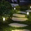 Compact Solar Powered Bollard Style Light - 4 Pack Installed along a pathway in a garden