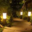 Compact Solar Powered Bollard Style Light - 4 Pack Installed along a pathway in a garden