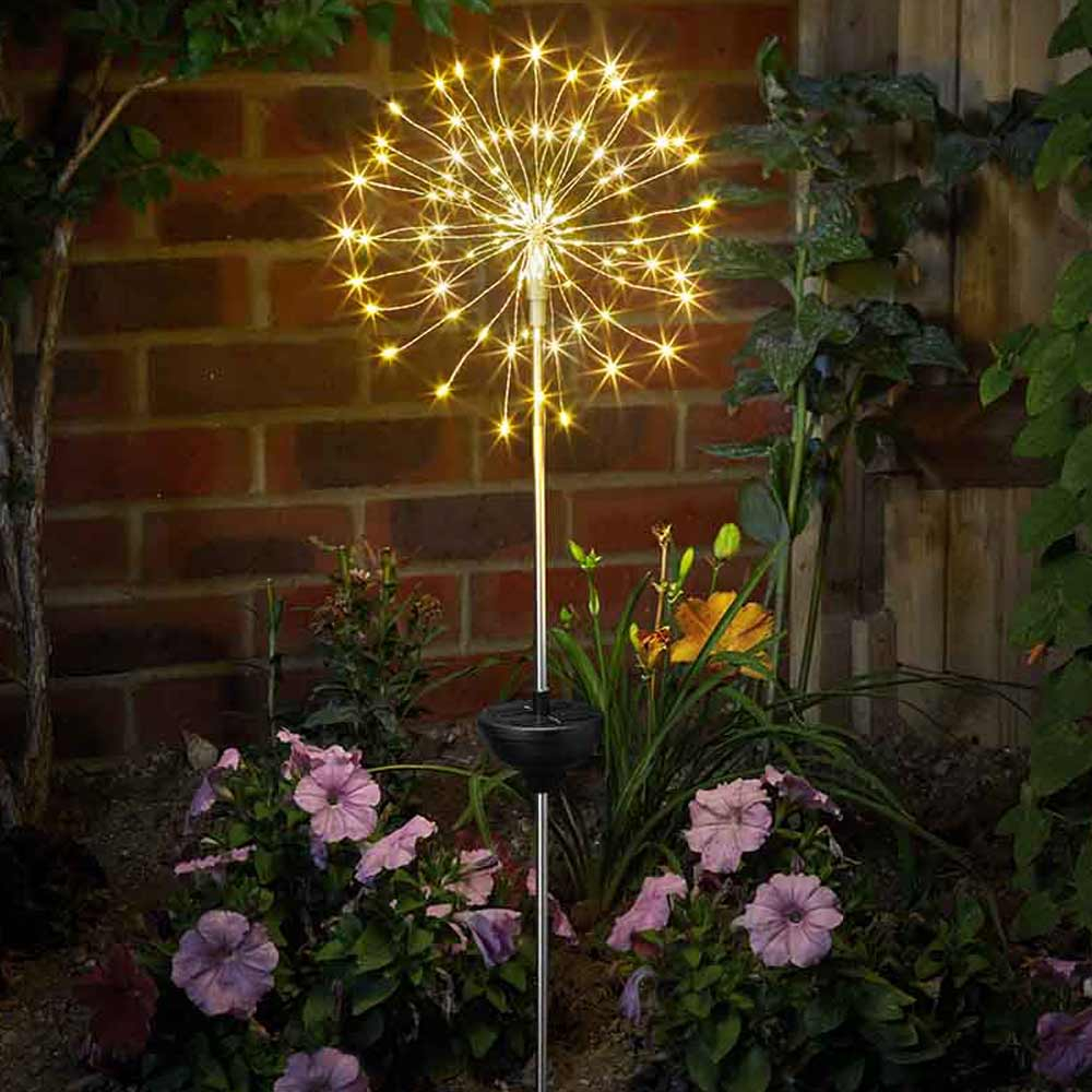 Solar Starburst Garden Stake Lights at night in garden